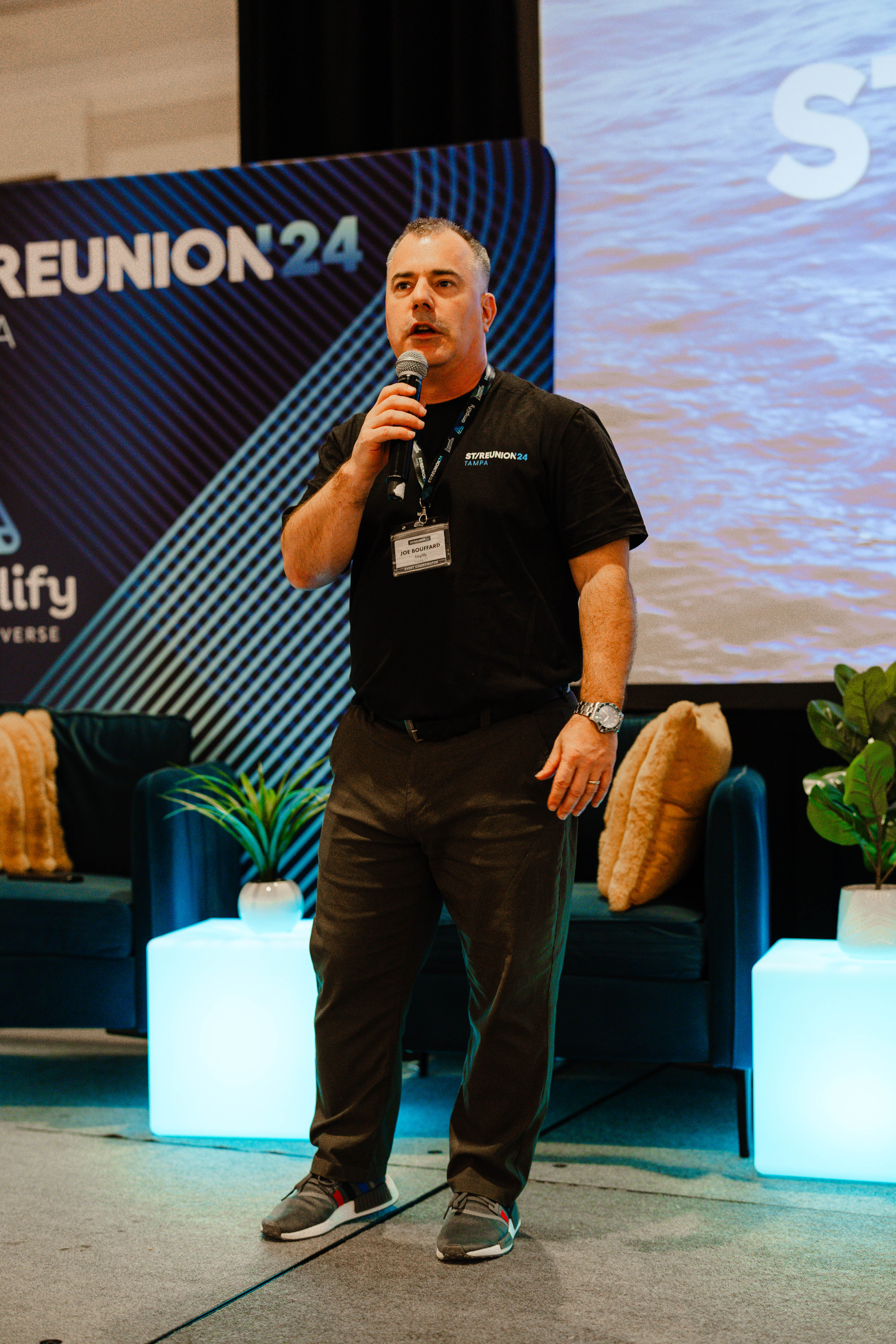 Joe Bouffard speaking with a microphone on a conference stage